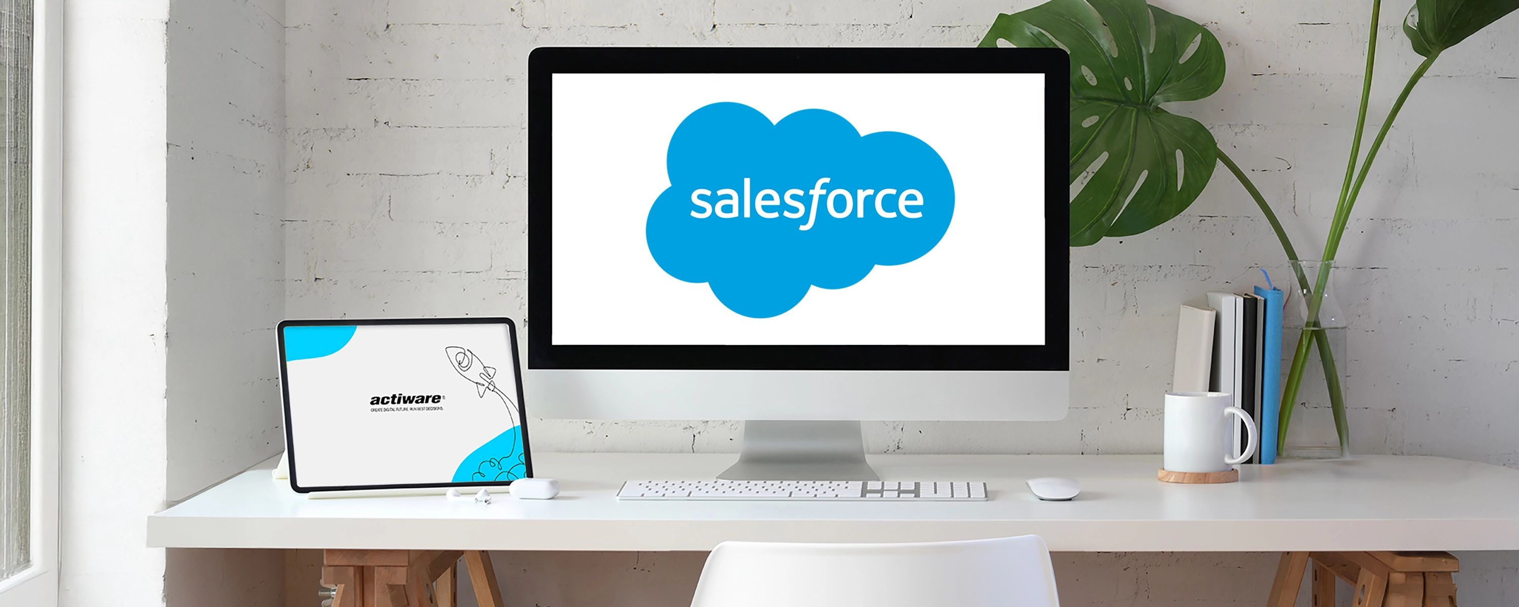 Ein Computerbildschirm mit dem Salesforce-Logo und ein Tablet mit dem actiware-Logo stehen auf einem modernen, aufgeräumten Schreibtisch.