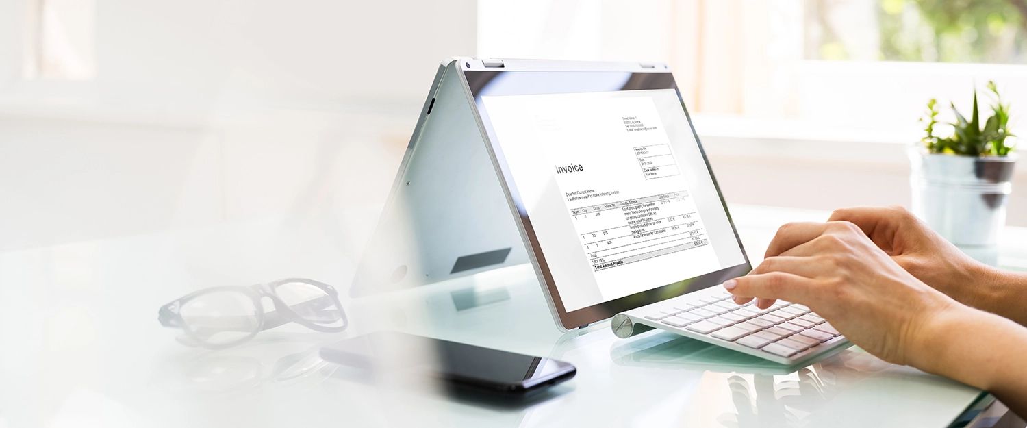 Digitale Rechnung (Invoice) auf einem Laptop-Bildschirm wird bearbeitet.