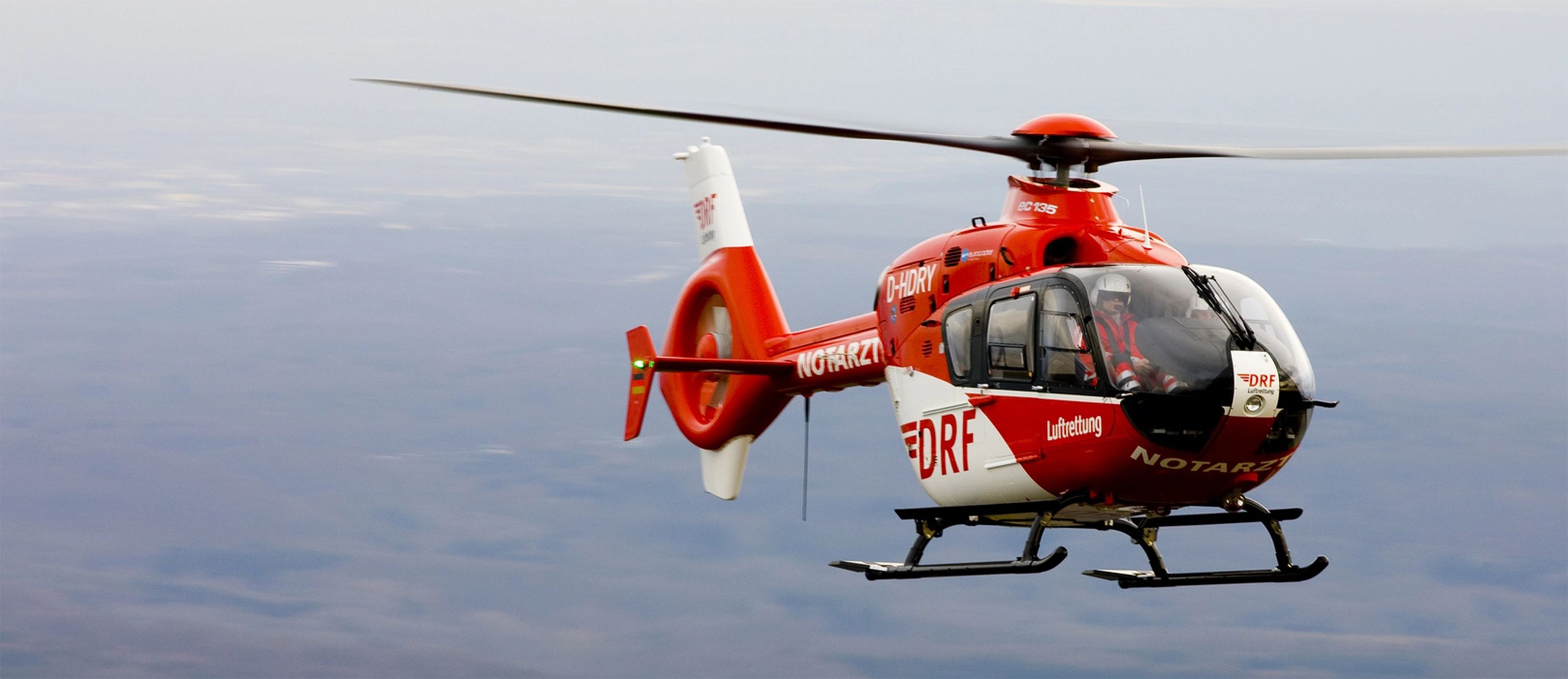 Roter DRF-Luftrettungshubschrauber im Flug – schnelle und zuverlässige Notfallrettung mit moderner Luftfahrttechnologie.