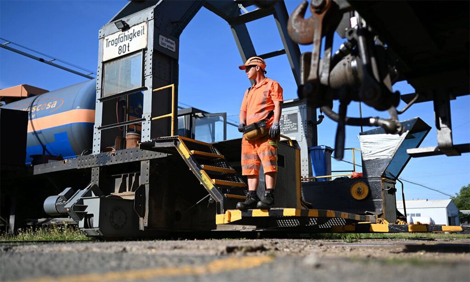 Mitarbeiter der Franz Kaminski Waggonbau GmbH bei der Arbeit auf einem Industriegelände – Instandhaltung und Wartung von Kesselwagen mit moderner Hebetechnik.