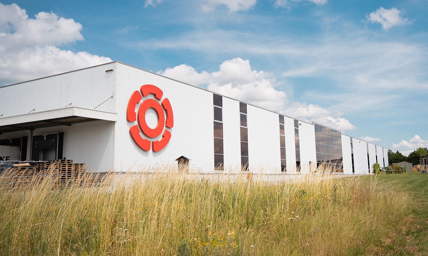 Rosenberg‑Firmengebäude mit großem roten Logo an der Fassade – moderner Produktions‑ und Logistikstandort des Lüftungs‑ und Klimatechnikherstellers.