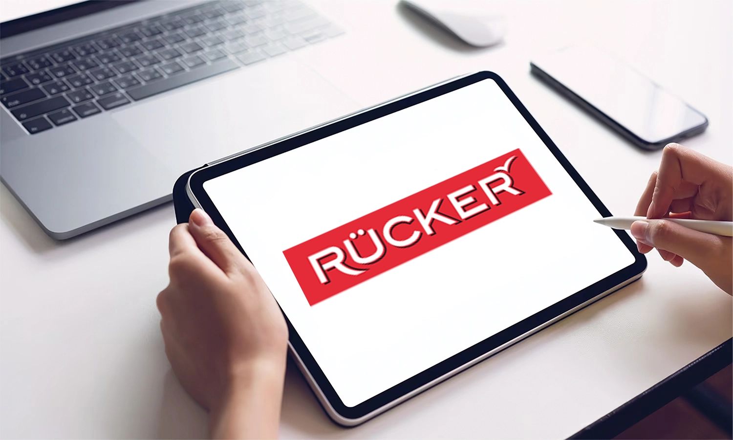 Rücker‑Logo auf Tablet‑Bildschirm – digitales Branding der norddeutschen Familienmolkerei und Herstellerin von Käse‑ und Milchprodukten.