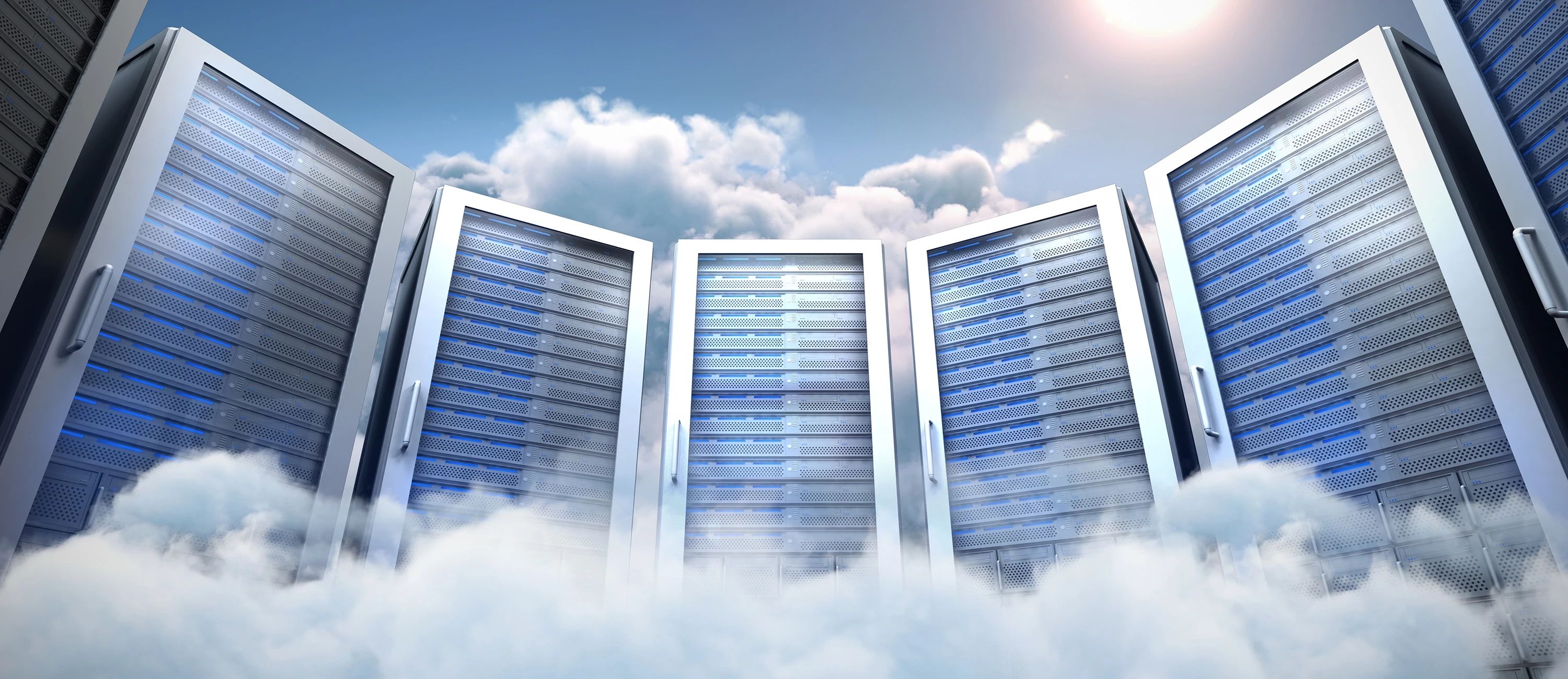 Große Reihe von silbergrauen Serverschränken, die in den Himmel ragen und von Wolken umgeben sind.