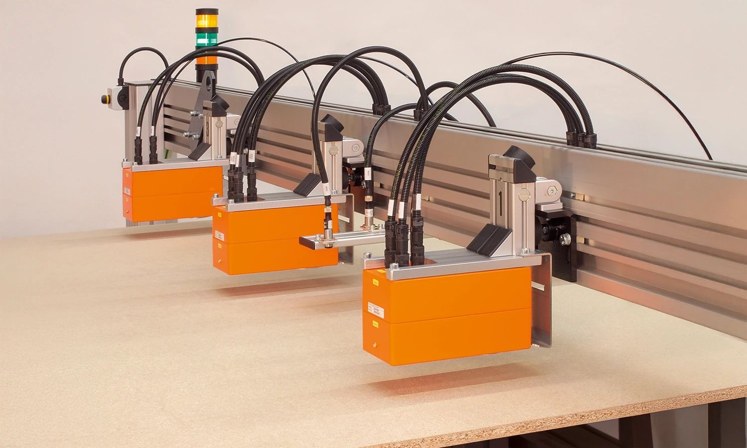 Messsystem von Fagus GreCon mit drei orangefarbenen Sensoren – präzise industrielle Messtechnik zur Qualitätskontrolle und Dickenmessung von Plattenmaterial.