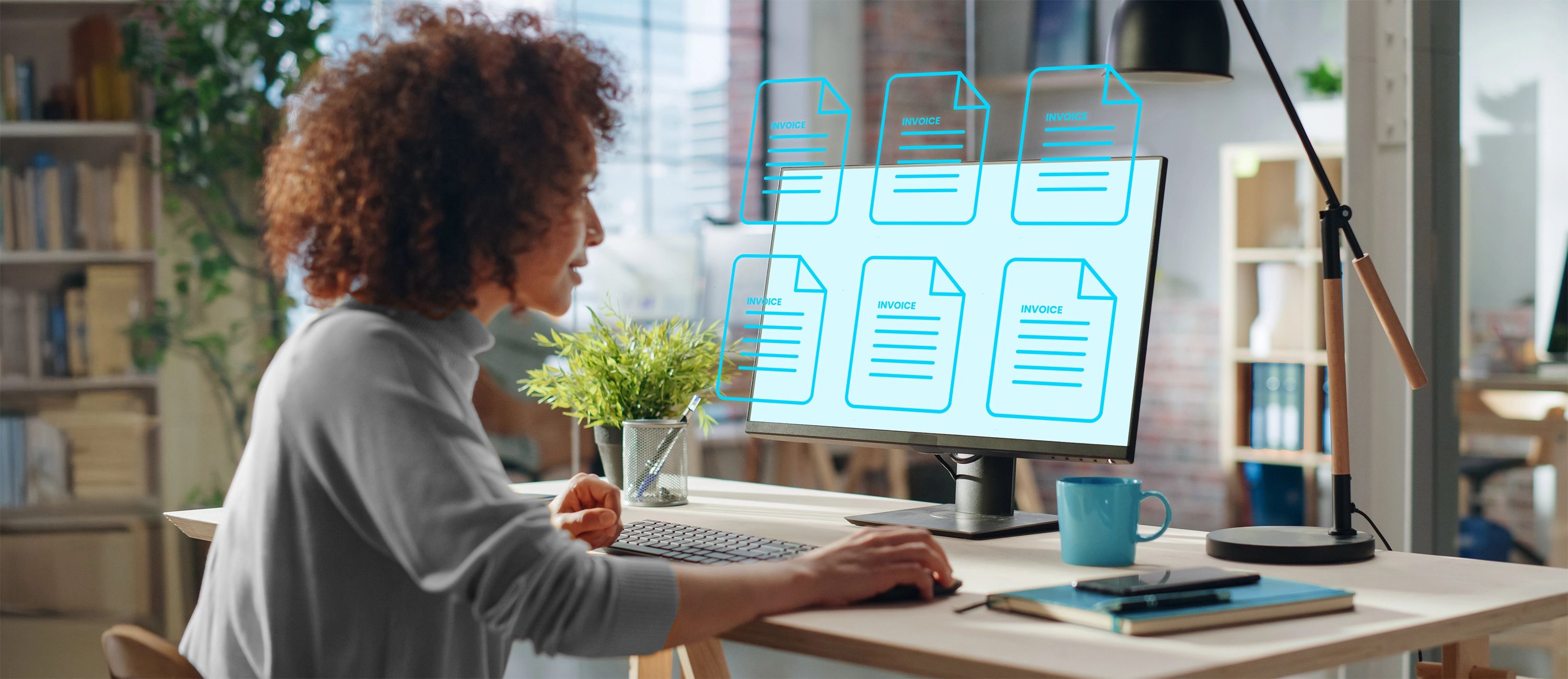 Eine Frau mit lockigen Haaren sitzt in einem Büro vor einem Computerbildschirm, der eine digitale Darstellung von E-Rechnungen (E-Invoices) mit dem Wort "Invoice" in leuchtendem Blau anzeigt.
