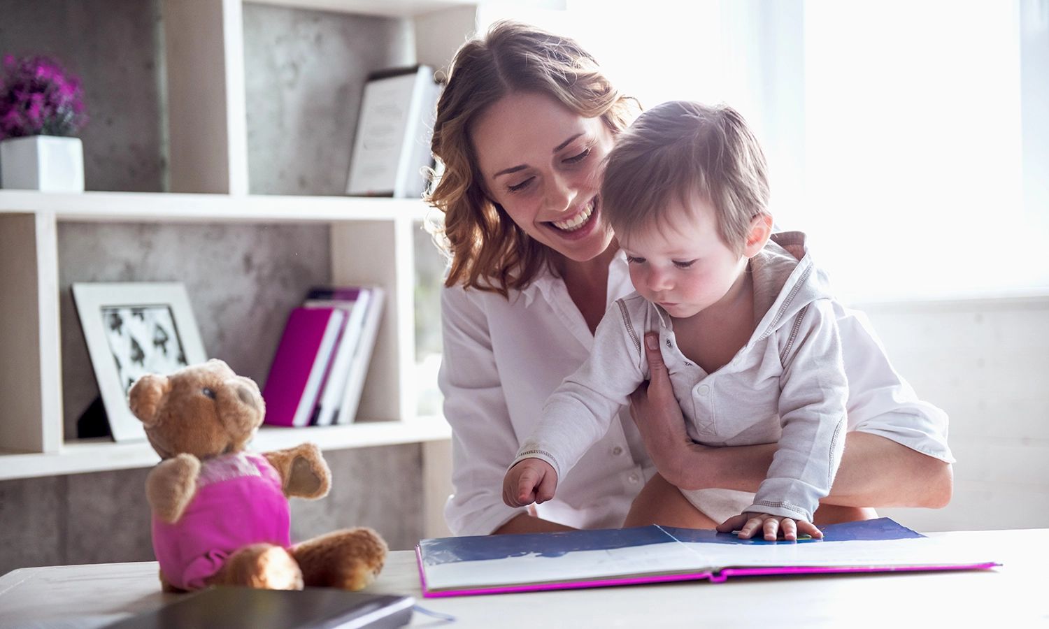 Mutter spielt mit Kleinkind am Tisch