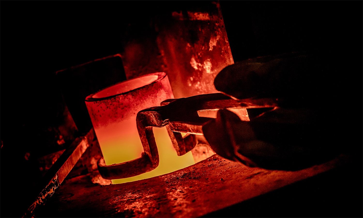 Glühender Schmelztiegel mit geschmolzenem Metall – Symbol für den Schmelzprozess in der Edelmetallproduktion von Heimerle + Meule und für präzise Metallverarbeitung in hoher Qualität.