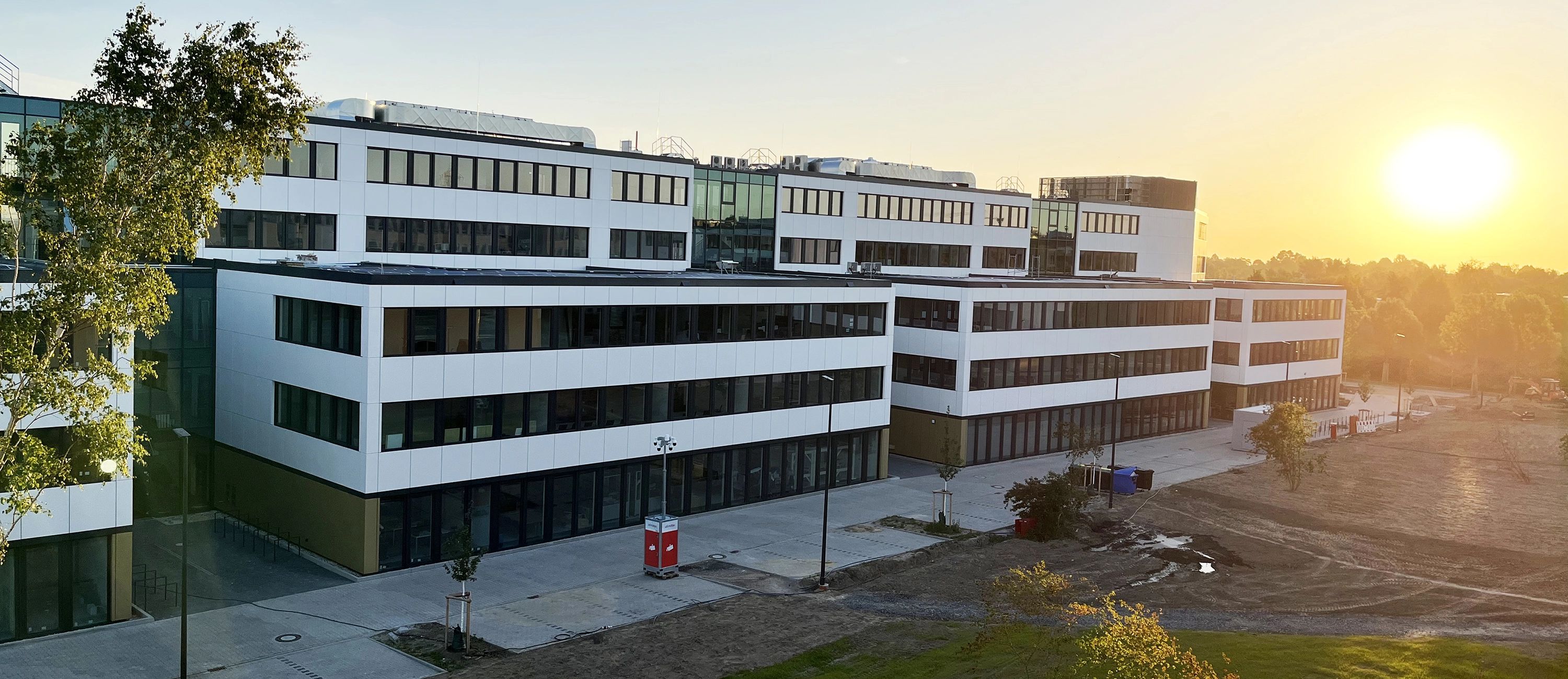 Firmengebäude von ACTIWARE Development im Sonnenaufgang, moderne Glas- und Fassadenarchitektur
