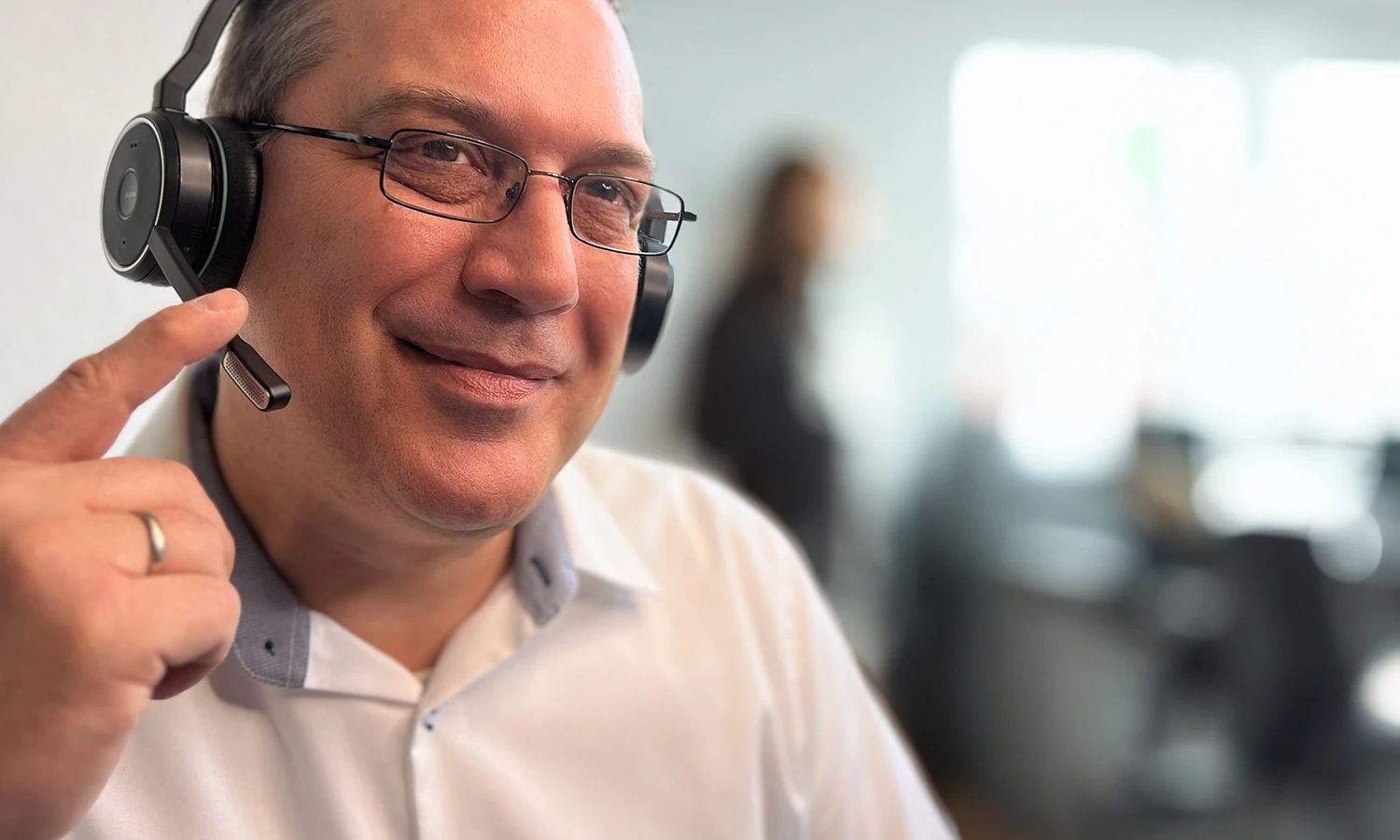 Ein freundlich wirkender Support-Mitarbeiter mit Headset.