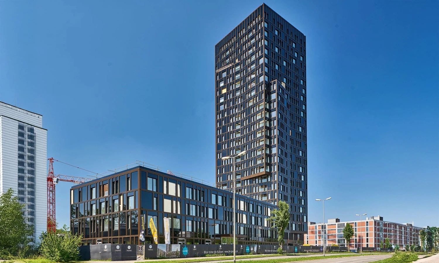 Hochhaus und Gebäudekomplex mit Geilinger-Stahlbaukonstruktion – modernes Architekturprojekt mit innovativer Tragwerkstechnik und eleganter Glasfassade.