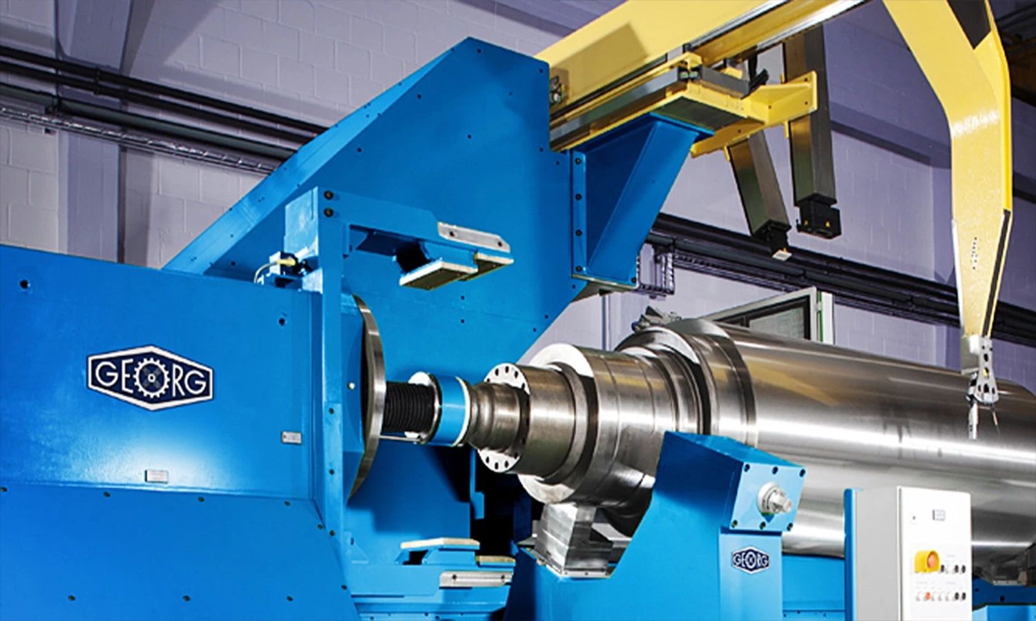 Präzisionsmaschine von Heinrich Georg – industrielle Hochleistungsanlage in blauem Design für die Metallbearbeitung und Fertigung von Walzen und Komponenten.