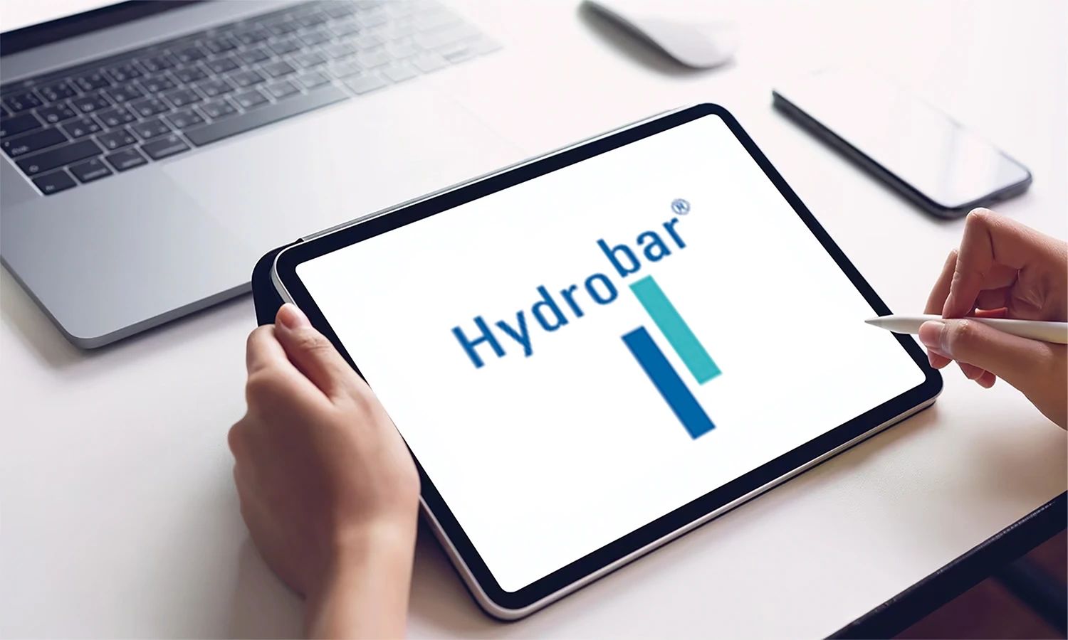 Tablet mit HydroBar‑Logo – Symbol für digitale Servicekompetenz und innovative Hydraulik‑ und Pneumatiklösungen des Unternehmens.
