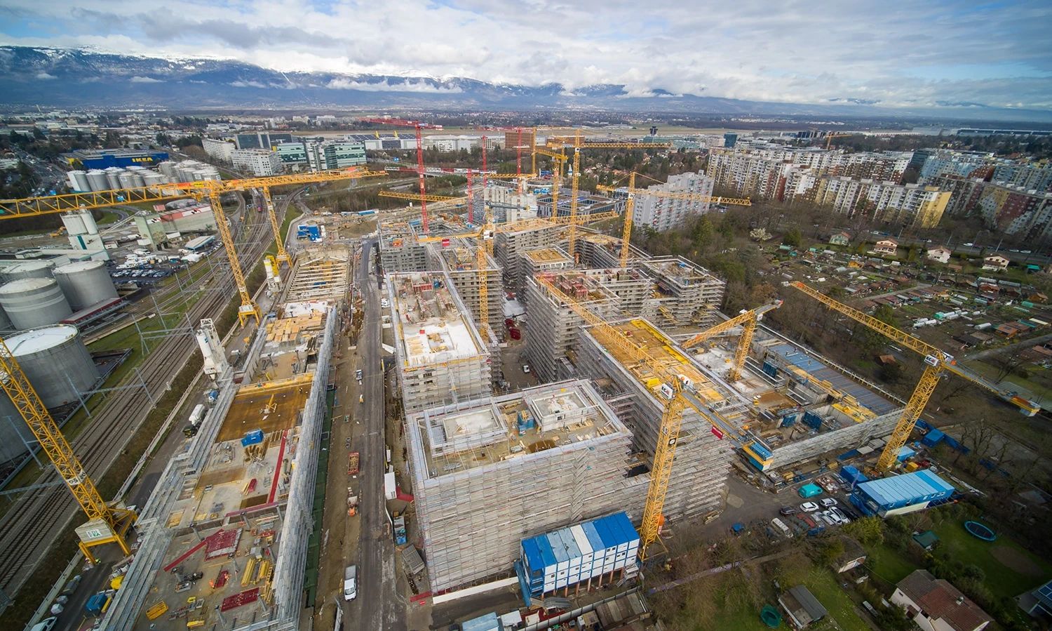 Großbaustelle mit mehreren Kränen und Gebäudekomplexen – Luftaufnahme eines urbanen Bauprojekts mit Gebäudetechniklösungen von Roth.